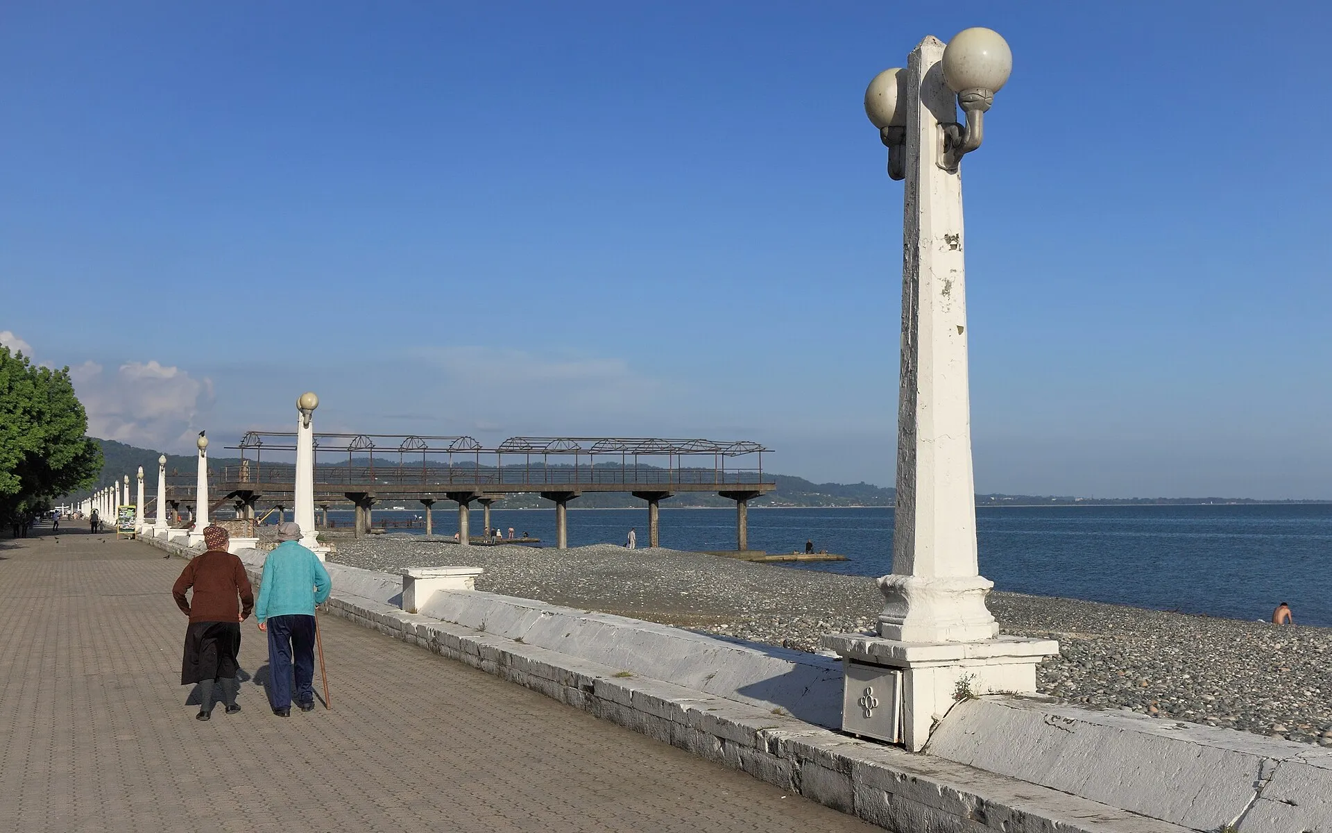 Люди гуляют по набережной Махаджиров в Сухуме у Чёрного моря